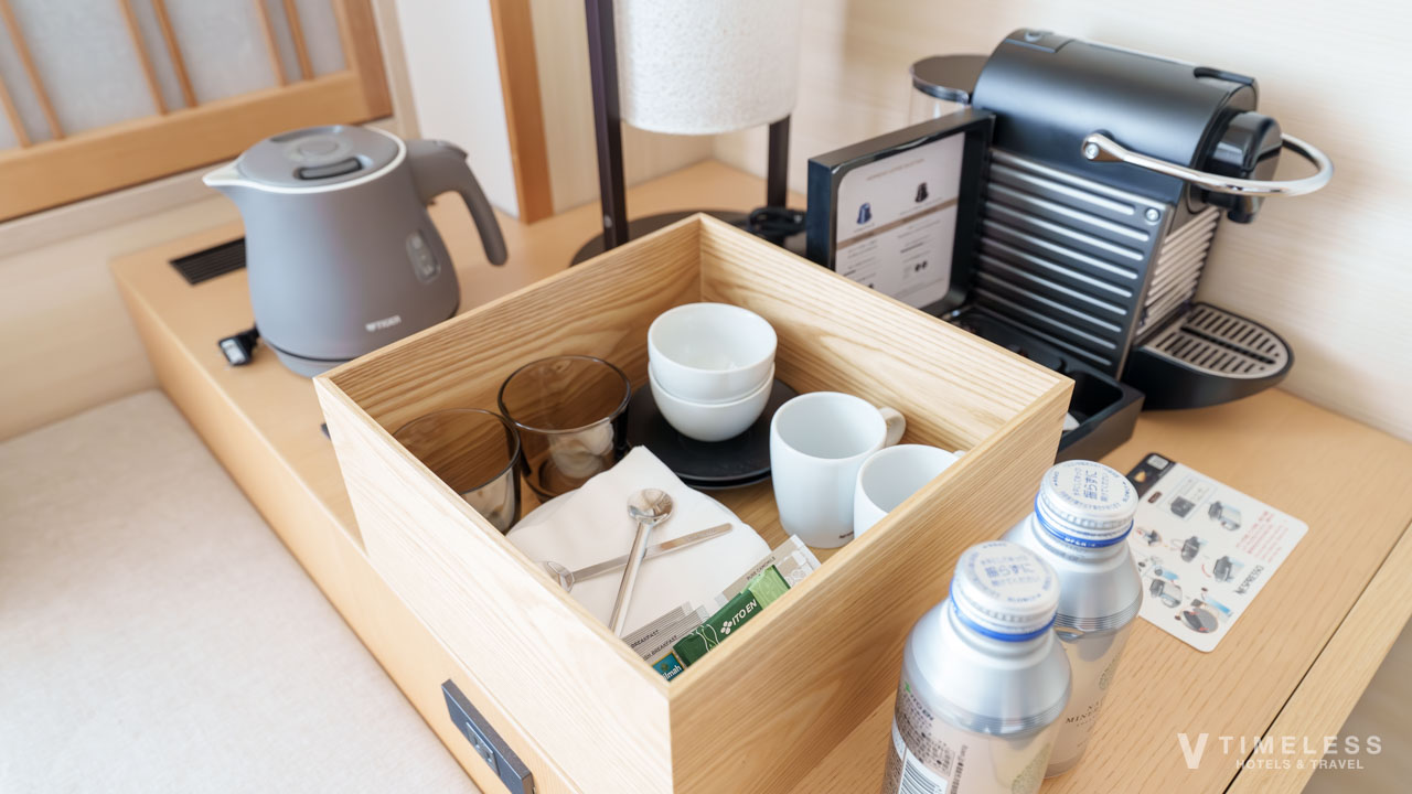 ミニバーには、ネスプレッソのコーヒーメーカー、お茶、カップ、ケトルなどがあり、その下にはミニ冷蔵庫が収納されています。