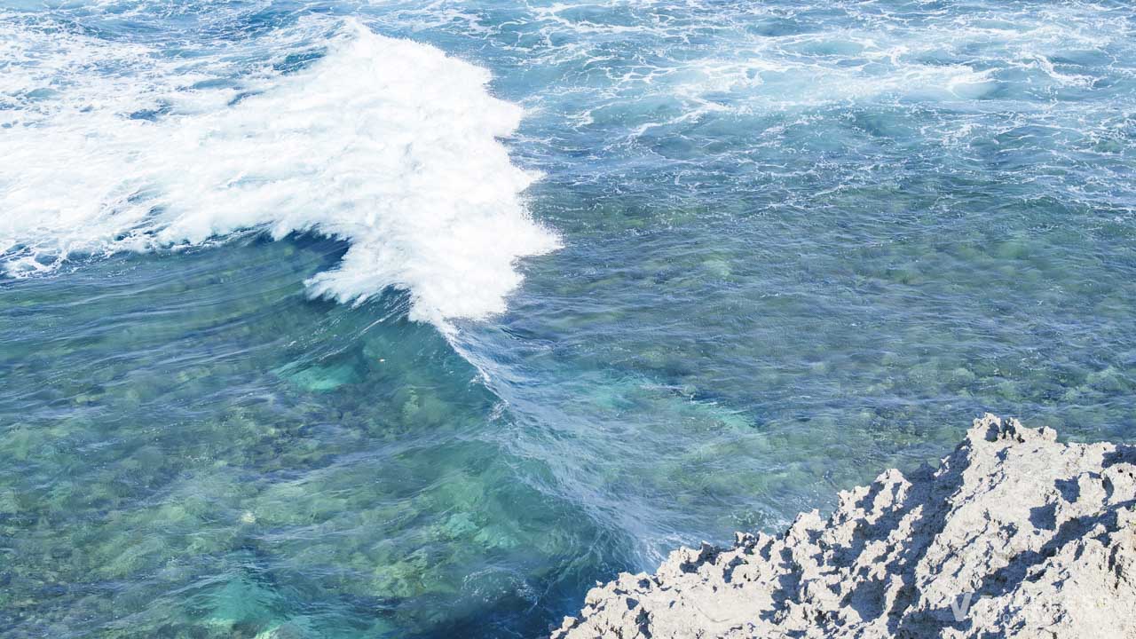 万座毛の断崖下に打ち寄せる白波と透明度の高い沖縄の海