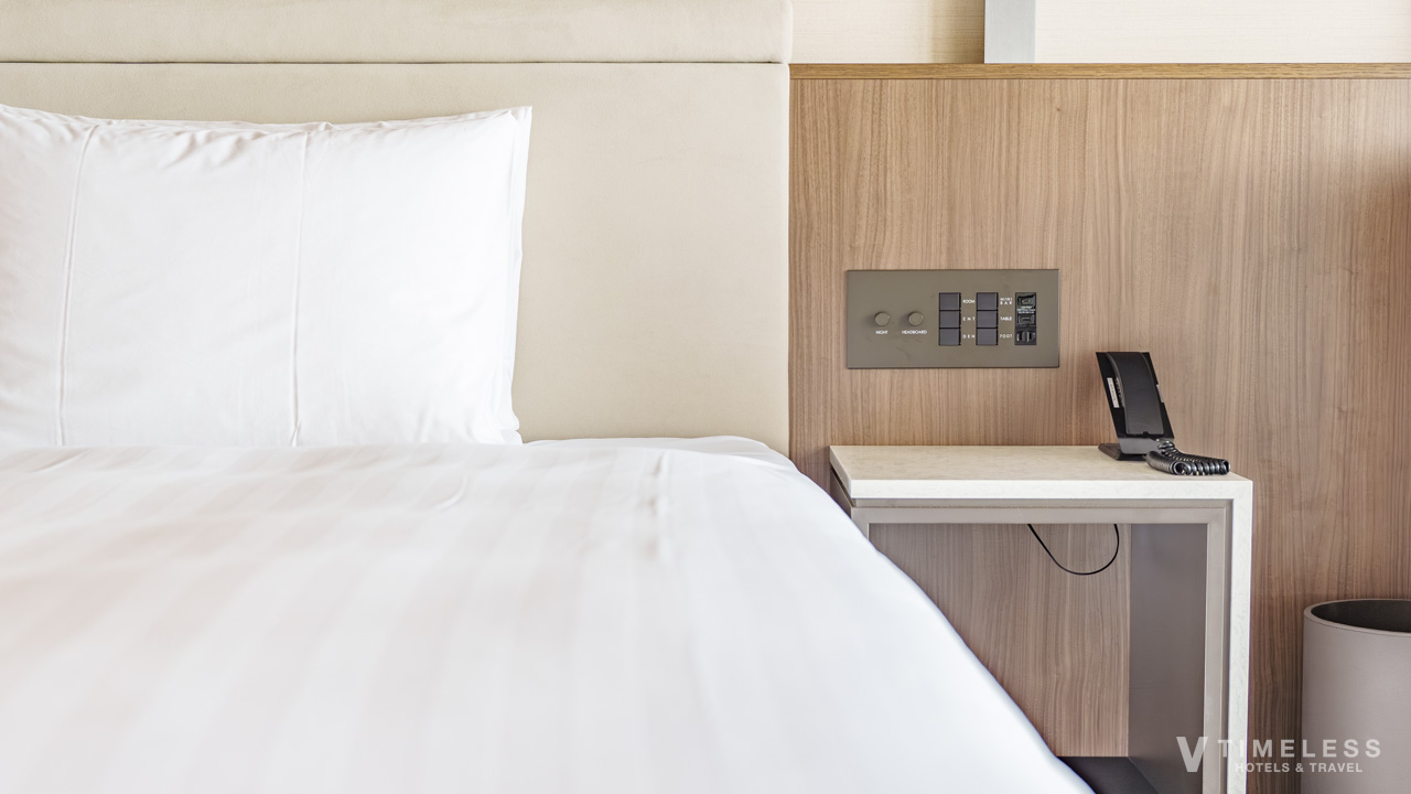 オリエンタルホテル沖縄 クラブルームのベッドサイド｜機能的なスイッチと落ち着いた客室空間