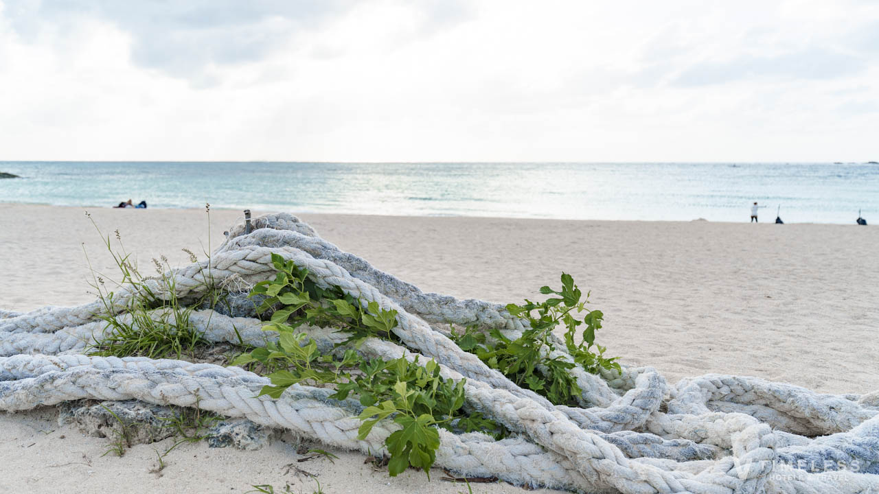 残波ビーチの砂浜に置かれたロープと静かな海景色