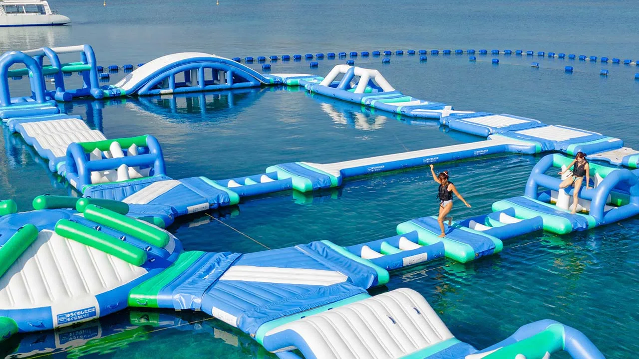 透き通る青い海に浮かぶ海上アスレチックで思い切りはしゃぐANAインターコンチネンタル万座ビーチリゾートの非日常体験