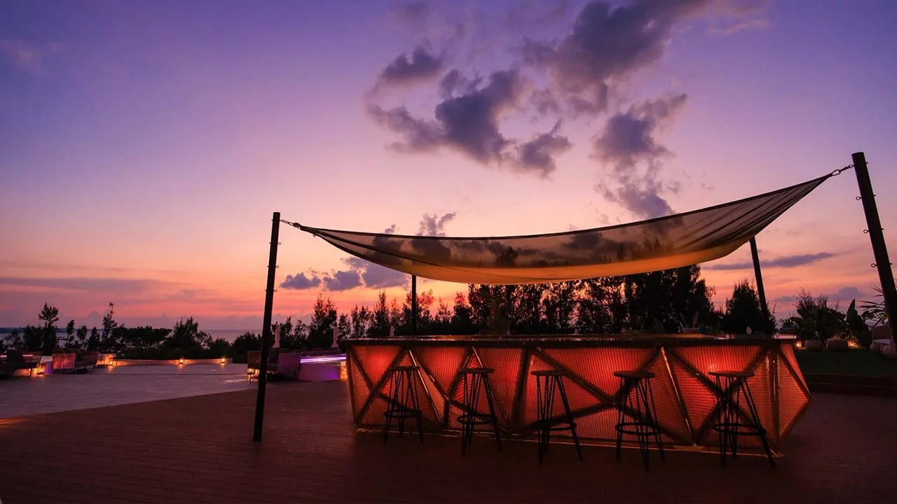 AQUASENSE Hotel & Resortのプールサイドバー。夕焼けのグラデーションに染まる空と心地よい波音に包まれる空間