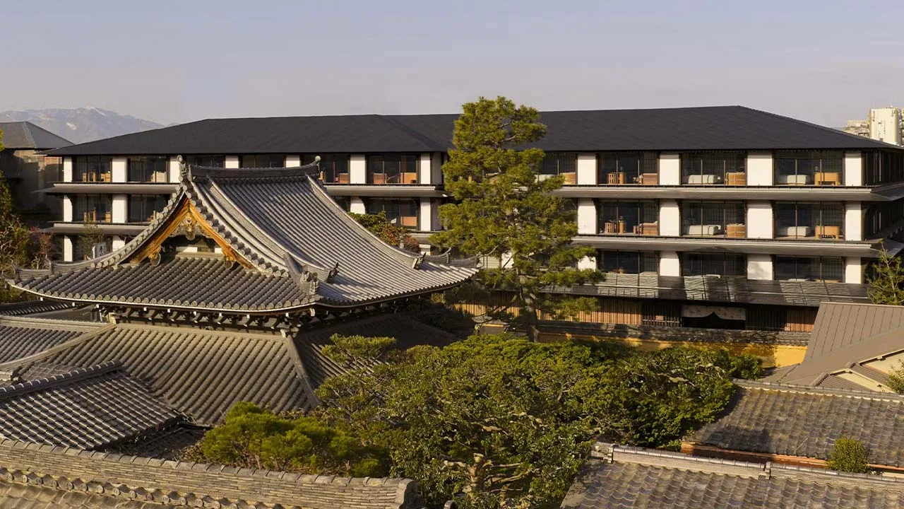 建仁寺の伝統的な瓦屋根の奥に佇む、歴史的景観に美しく調和したカペラ京都の外観