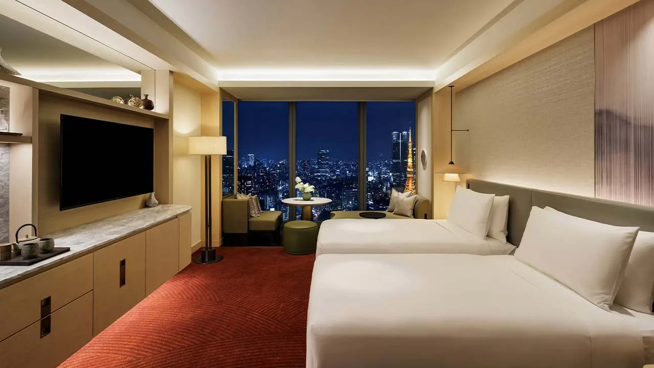 フェアモント東京のラグジュアリーな客室。ベッドに横たわりながら東京タワーの夜景を眺められる、夢のようにロマンチックな滞在。