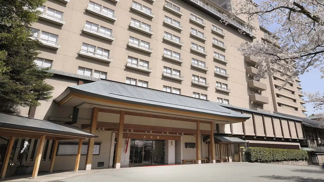 春爛漫の桜に彩られた下呂温泉 水明館のエントランス。心躍る温泉旅行の始まりを予感させる美しい外観