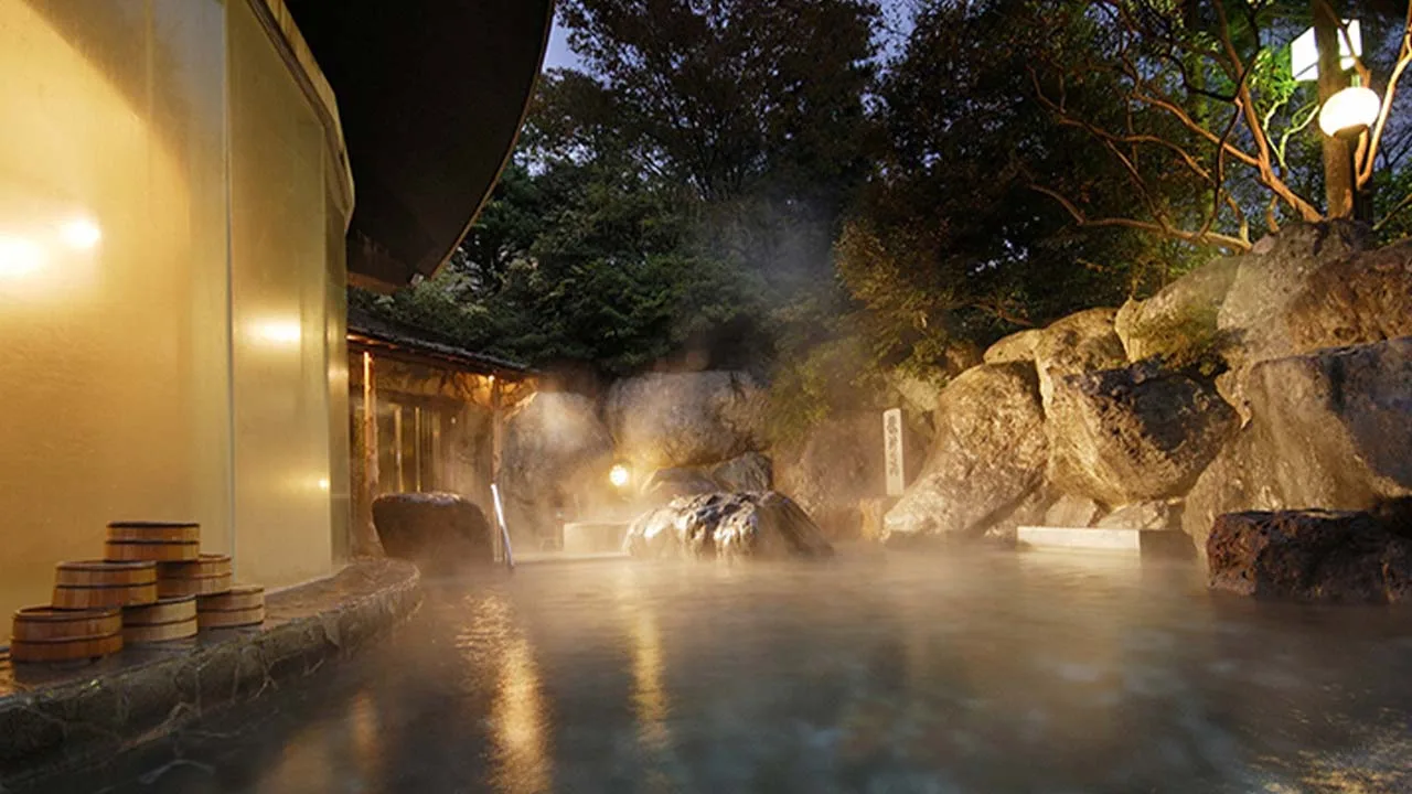 幻想的な湯けむりとライトアップに包まれる下呂温泉 水明館の夜の露天風呂。星空の下で癒やされる至福のバスタイム