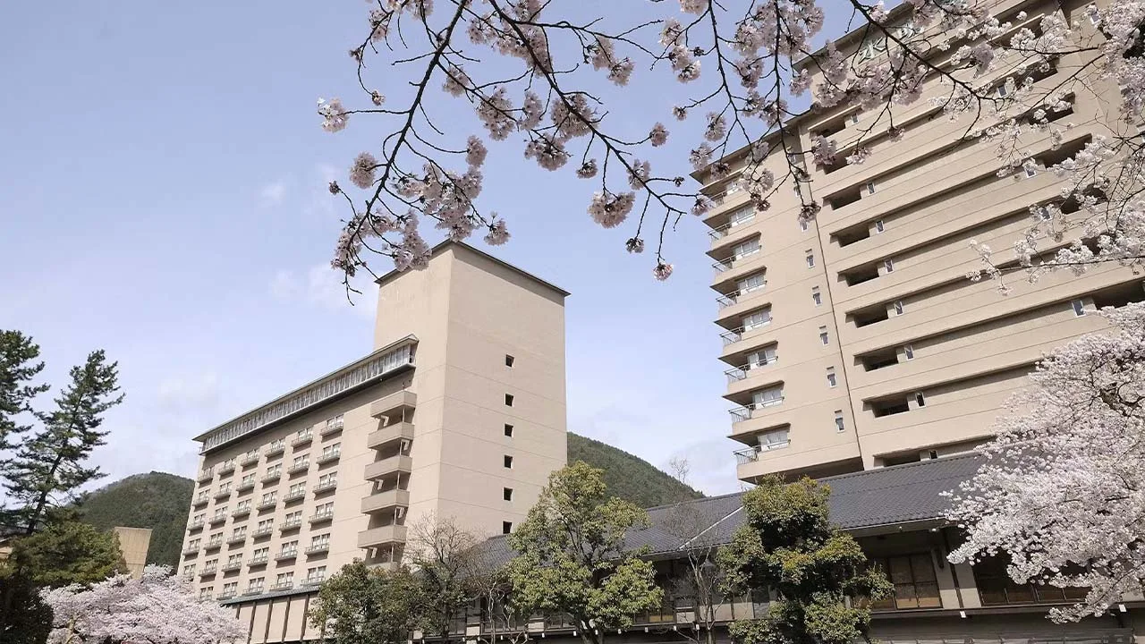 満開の桜越しに見上げる下呂温泉 水明館の壮大な外観。春風を感じながらゆったり過ごす大人のご褒美旅