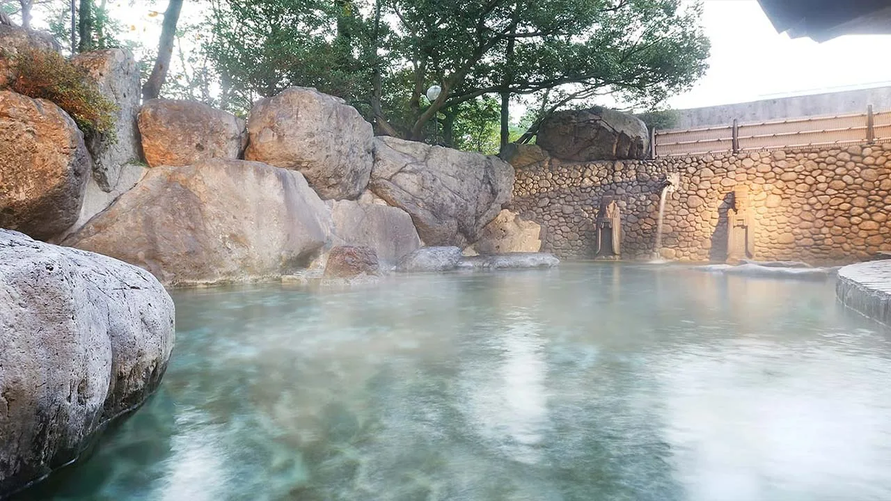 豊かな自然と野趣あふれる岩風呂が魅力の下呂温泉 水明館の露天風呂。木漏れ日を浴びながら楽しむ贅沢な湯浴み