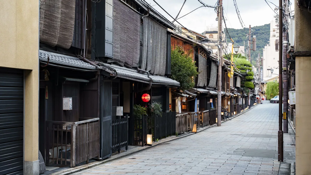 二階に簾を掛けた茶屋建築が並ぶ、祇園の通り
