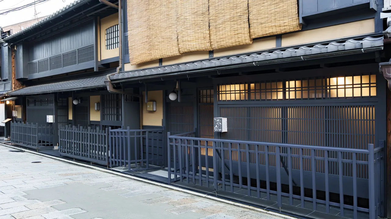 夕暮れ、簾の内に灯りがともる祇園の町家