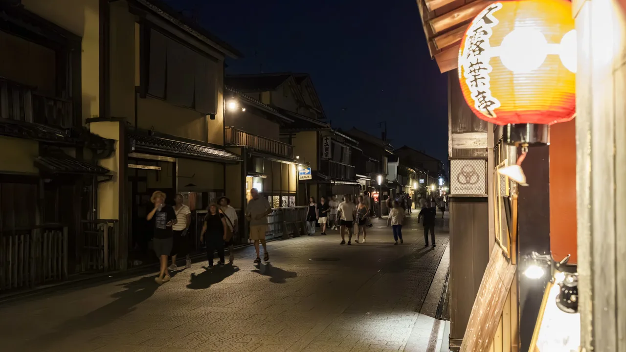 提灯の灯りに照らされた夜の花見小路と、行き交う人