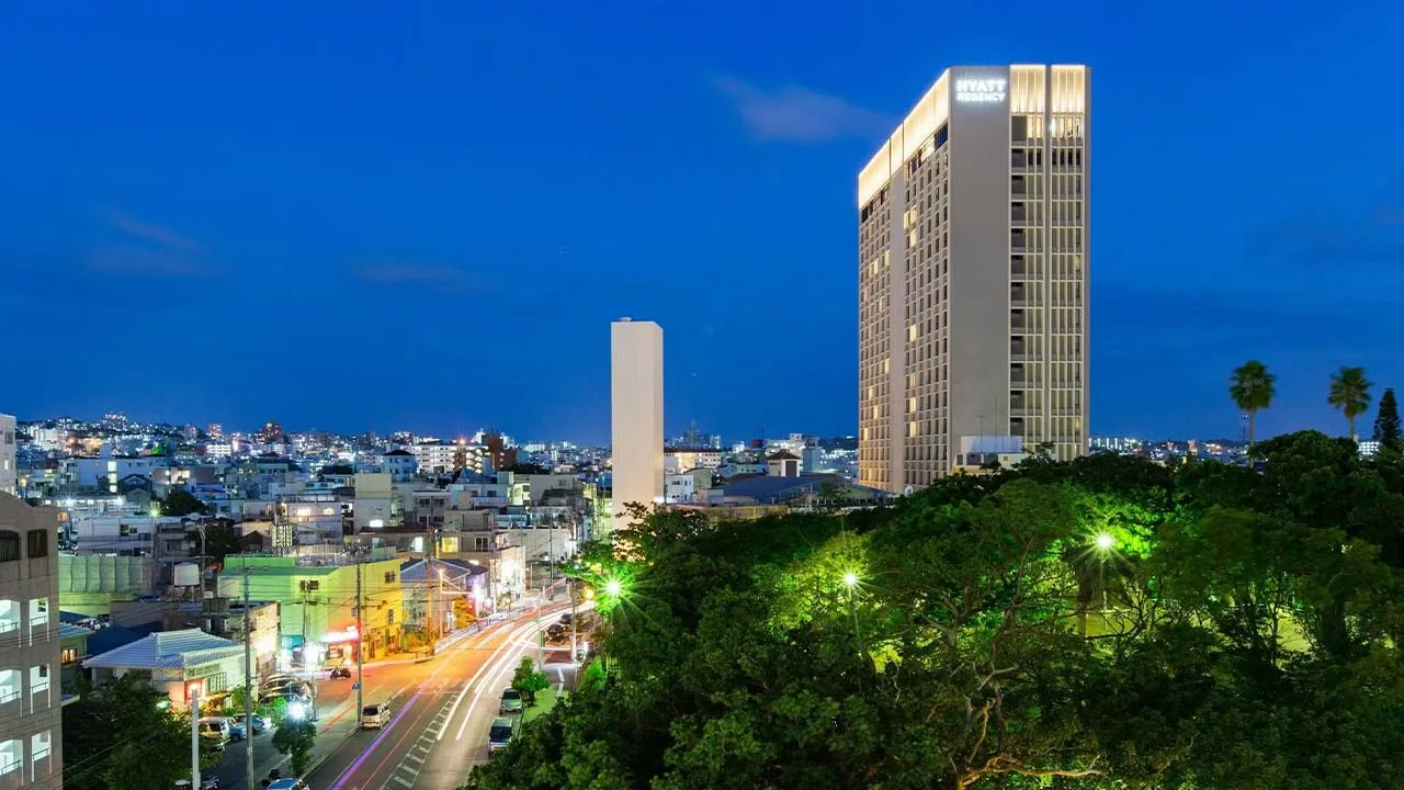 夕暮れの街並みにそびえ立つハイアット リージェンシー 那覇 沖縄の外観と那覇の景色