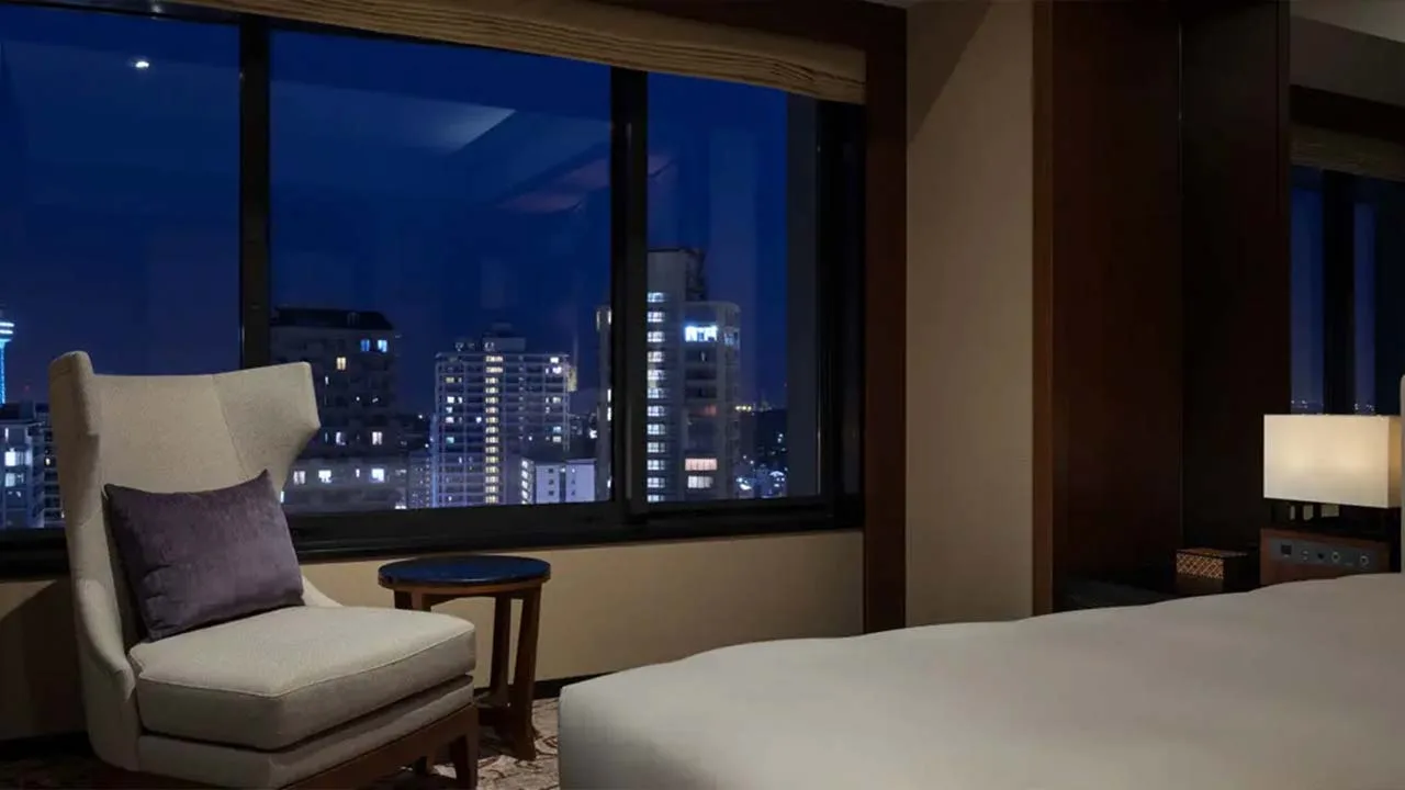 煌めく横浜の夜景をプライベートな空間で堪能できるハイアット リージェンシー 横浜の客室。窓際のチェアに腰掛けて眺める宝石のような街の灯りがロマンチックな夜を演出します。