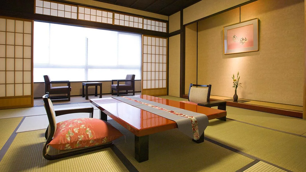 柔らかな光が差し込む料理旅館 金沢茶屋の和室。畳の香りと美しい朱塗りの座卓に心癒される、ほっと一息つけるくつろぎの空間。
