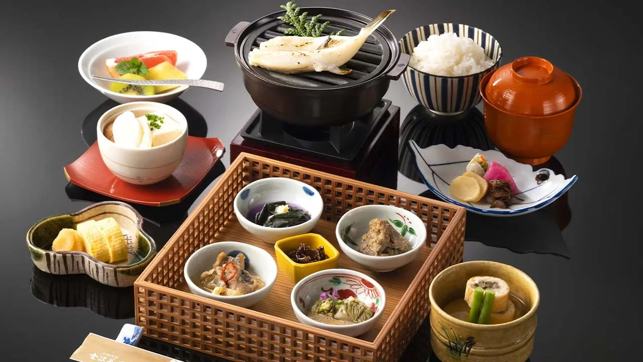 木枠に可愛らしく盛られた小鉢や網焼きの魚が並ぶ料理旅館 金沢茶屋の朝食。身体の隅々まで元気をもらえる彩り豊かな和食で、旅の朝を飾る優雅な時間。