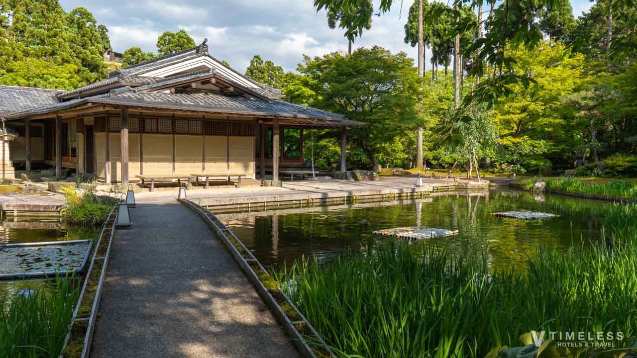 しょうざん庭園の峰玉亭と池、手前に咲く花菖蒲