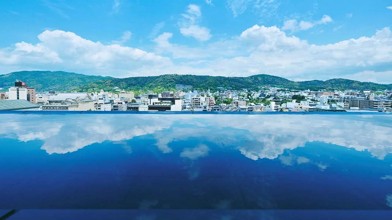水鏡に青空と東山の稜線が美しく映り込む、四条河原町温泉 空庭テラス京都の開放的な絶景ルーフトップ。京都の空に溶け込むような非日常の時間が流れます。