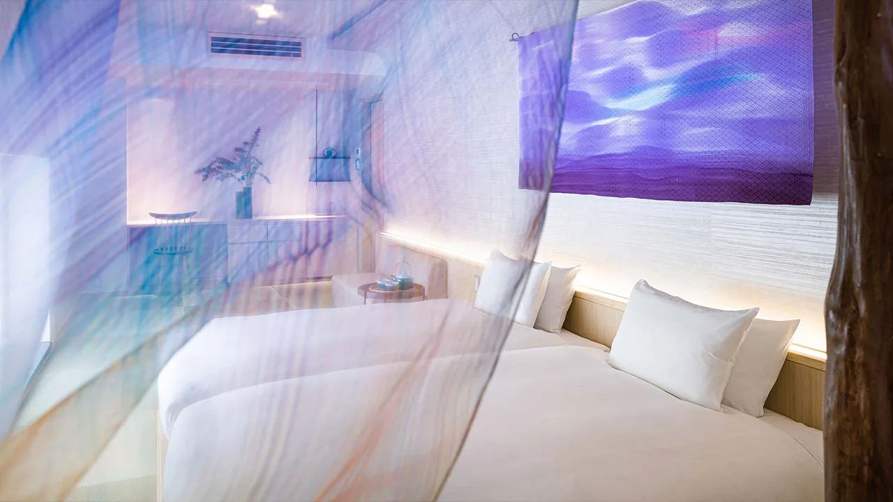 THE JUNEI HOTEL 京都のベッドルーム。幻想的な紫のファブリックに包まれた和空間で、心身を優しく癒やす至福の眠りを。