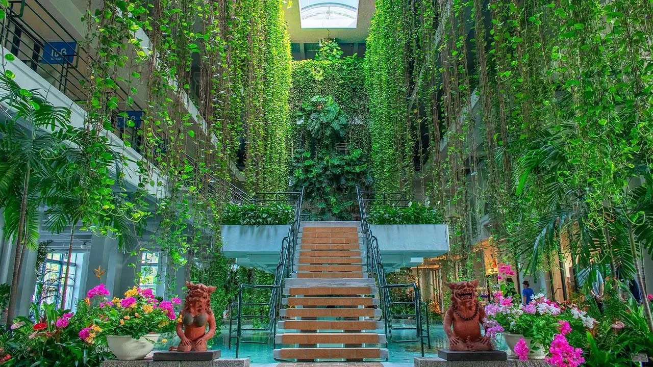 鮮やかな南国の花々とダイナミックな植物に彩られたザ・ムーンビーチ ミュージアムリゾートの吹き抜け階段。愛らしいシーサーが出迎えてくれる心ときめくフォトジェニックな空間
